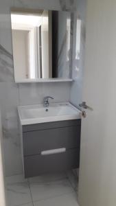 a bathroom with a sink and a mirror at Villa Melodia Xhek in Ksamil +21 photos