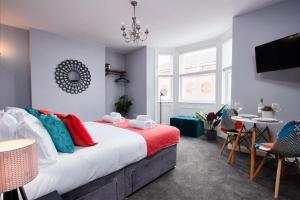 a bedroom with a large bed with colorful pillows at Delven House, Apartment 2 in Castle Donington