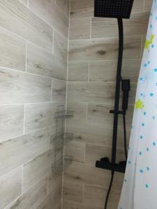 um chuveiro na casa de banho com uma cortina de chuveiro em M3 - Mieszkanie 2 pokoje , kuchnia , łazienka em Grodzisk Mazowiecki