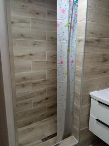 um chuveiro com uma porta de vidro com confetes em M3 - Mieszkanie 2 pokoje , kuchnia , łazienka em Grodzisk Mazowiecki