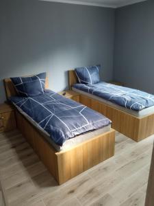 Duas camas num quarto com almofadas azuis em M3 - Mieszkanie 2 pokoje , kuchnia , łazienka em Grodzisk Mazowiecki