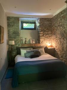 una camera con letto e parete in pietra di Villa Bacchetta - Stone Cottage a Oleggio Castello