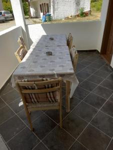 Vikendica في كانج: طاولة وكراسي يجلسون على شرفة مع طاولة وطاولة وكراسي
