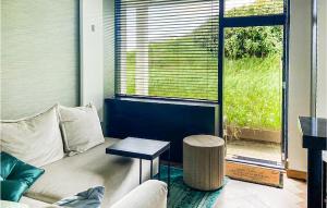 salon z kanapą, stołem i oknem w obiekcie De Duinparel w mieście Bergen aan Zee
