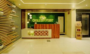 hol restauracji ze złotym znakiem na ścianie w obiekcie Treebo Trend Golden Nest w mieście Bhubaneswar
