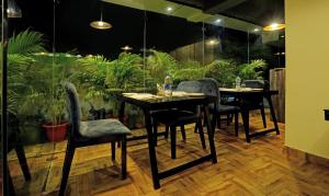 una sala da pranzo con tavoli, sedie e piante di Treebo Trend Golden Nest a Bhubaneshwar