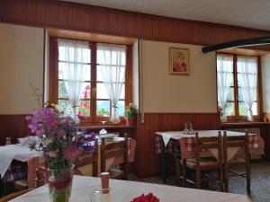 a dining room with two tables and two windows at Locanda Belvedere Pey in Zerba