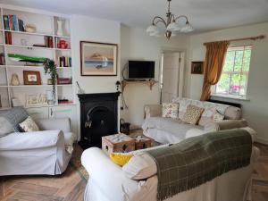 萊特肯尼的住宿－Kiltoy Cottage, Cosy 2 bedroomed Gate Lodge Cottage，客厅设有两张沙发和一个壁炉