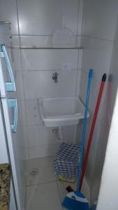a small bathroom with a sink and two mop at Apartamento a 50 metros da praia in Ubatuba