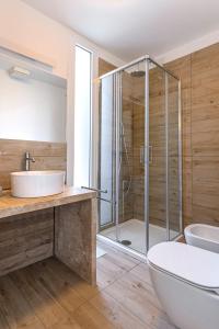 a bathroom with a shower and a toilet and a sink at Capo Falcone Charming Apartments in Stintino