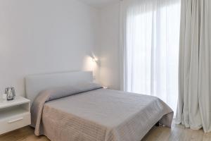 a bedroom with a bed and a large window at Capo Falcone Charming Apartments in Stintino