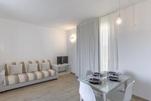 a living room with a table and a couch at Capo Falcone Charming Apartments in Stintino
