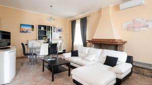 - un salon avec un canapé blanc et une cheminée dans l'établissement Welcomely - Casa Peppe, à Domusnovas