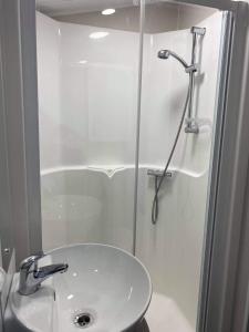 a bathroom with a shower and a white sink at Kellys Holiday Homes 24 Willerby 2 bedrooms caravan in Weeley +29 photos
