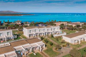 an aerial view of a house with the ocean in the background at Capo Falcone Charming Apartments in Stintino