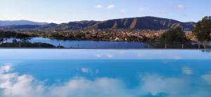 a large body of water with a city in the background at Domus Lake Resorts in Villa Carlos Paz
