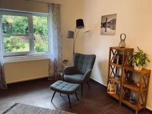 a living room with a chair and a lamp at Haus Lavendel in Vinningen