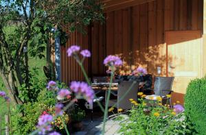 eine Terrasse mit einem Tisch, Stühlen und Blumen in der Unterkunft Ferienwohnung Pölzl in Chieming