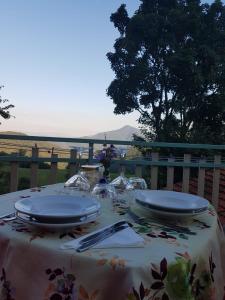 a table with plates and glasses on top at Locanda Belvedere Pey in Zerba