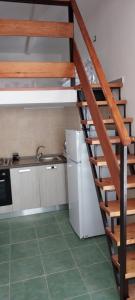 eine Küche mit einer Wendeltreppe in einer Küche mit einem Kühlschrank in der Unterkunft la lavanda 2 in Sapri