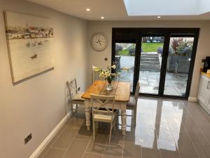 a dining room with a table and a clock on the wall at 17 Eastgate in Cowbridge +16 photos