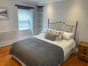 una camera da letto con letto, cuscini e finestra di 17 Eastgate a Cowbridge