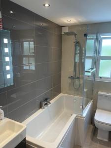 a bathroom with a tub and a toilet and a shower at 17 Eastgate in Cowbridge