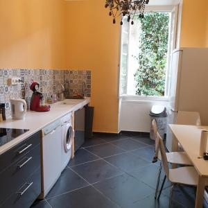 a kitchen with a sink and a washing machine at Appartement intra muros 8 personnes climatisé Wifi stationnement facile in Avignon