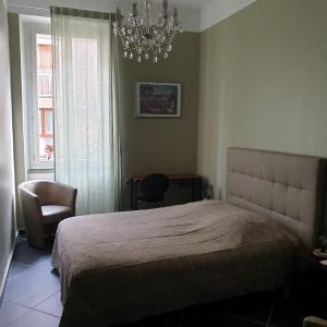 a bedroom with a bed and a chandelier at Appartement intra muros 8 personnes climatisé Wifi stationnement facile in Avignon