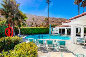 una piscina con sillas y una casa en Casa Mesa Permit# 2665, en Palm Springs