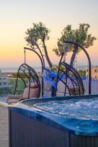 bañera de hidromasaje con 2 columpios junto a la piscina en Mesogios House Suites, en Lárnaca