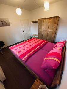 a large bed in a room with pink sheets at Haus Lavendel in Vinningen