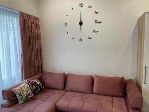 a large clock on the wall above a couch at Apartamenty MGA Lividus 15 in Świnoujście