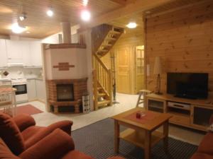 a living room with a fireplace in a log house at Ilvestie A in Syöte