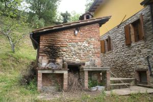 un viejo horno de ladrillo en el lateral de un edificio en Tradizione Toscana ristrutturata nel 2021, en Barga