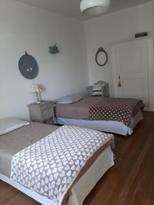 una camera da letto con due letti e un orologio a parete di Gîte des Agapanthes a Lacroix-sur-Meuse