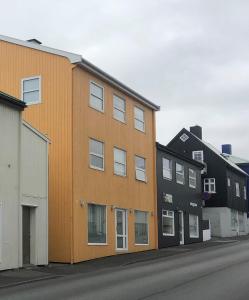 ein orangefarbenes Gebäude an der Straßenseite in der Unterkunft In the heart of Tórshavn in Tórshavn
