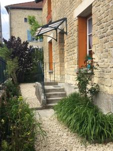 ein Backsteinhaus mit einer Treppe, die zu einer Tür führt in der Unterkunft L'Echappée Ardennaise - Gîte 6 places tout confort in Semuy