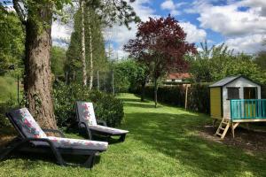 zwei Stühle neben einem Baum im Garten in der Unterkunft L'Echappée Ardennaise - Gîte 6 places tout confort in Semuy