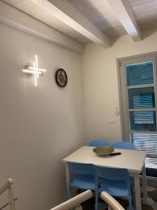 ein Zimmer mit einem Tisch und Stühlen sowie einer Uhr an der Wand in der Unterkunft Le Terrazze in Borgio Verezzi
