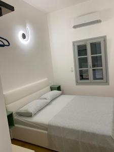 ein weißes Schlafzimmer mit einem Bett und einem Fenster in der Unterkunft Le Terrazze in Borgio Verezzi