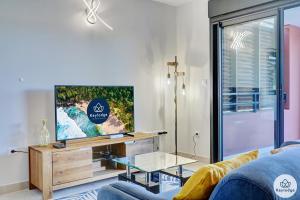 a living room with a tv and a blue couch at T3 - Leu Filao, classé 4 étoiles - 70m2 - Plage et Lagon de Saint-Leu in Saint-Leu