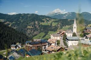 a small town in the mountains with a church at Hotel Plan Murin in La Valle