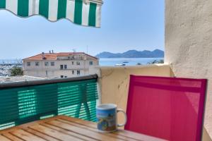 カンヌにあるIMMOGROOM - Sea View - Balcony - 5 min from the beach - AC - Wifiのコーヒーカップ(テーブルに座ったバルコニー)