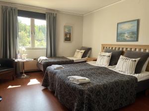 ein Hotelzimmer mit 2 Betten und einem Fenster in der Unterkunft Värdshuset Glada Hudik in Hudiksvall
