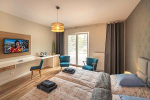 sypialnia z 2 łóżkami i biurkiem z krzesłami w obiekcie Apartamenty Mozaika - centrum Zdroju w mieście Lądek-Zdrój