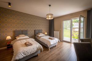 sypialnia z dwoma łóżkami i dużym oknem w obiekcie Apartamenty Mozaika - centrum Zdroju w mieście Lądek-Zdrój