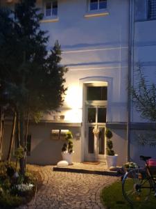 uma porta da frente de um edifício branco à noite em Morizan em Röbel