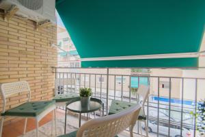 un balcone con tavolo e sedie e una piscina di Piso Estadio de los Carmenes a Granada
