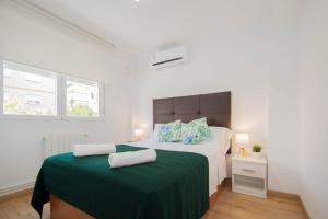 una camera da letto con un letto grande con una coperta verde di Piso Estadio de los Carmenes a Granada